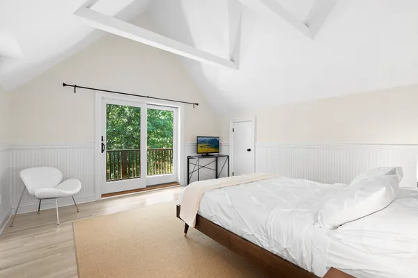 a bedroom with a bed and a large window