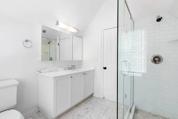 a bathroom with a sink a toilet and shower