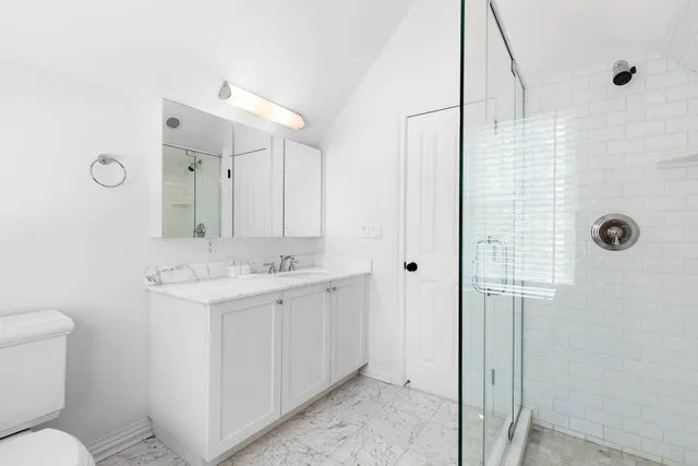 a bathroom with a sink a toilet and shower