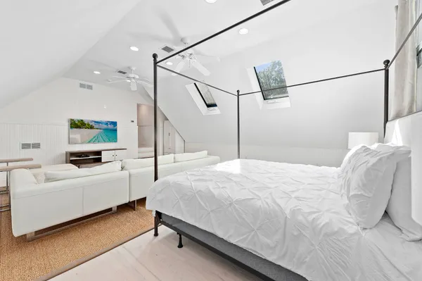 a bedroom with a bed a flat screen tv and a couch