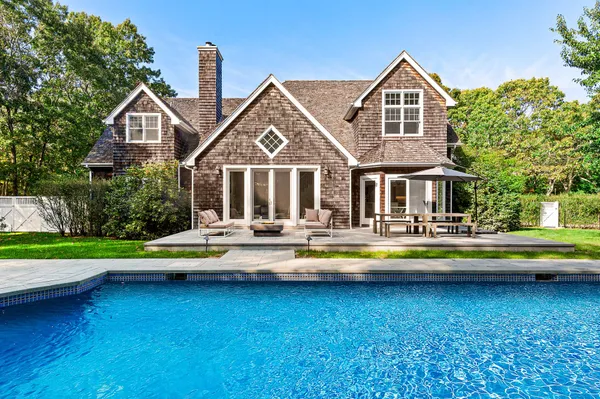 a view of a house with swimming pool and sitting area