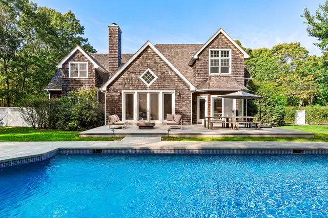 a view of a house with swimming pool and sitting area