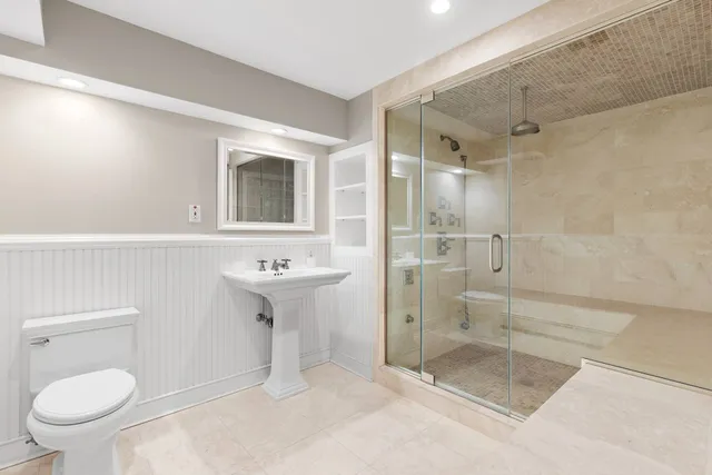 a bathroom with a shower sink mirror and toilet
