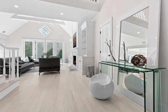 a living room with furniture a flat screen tv and a wooden floor