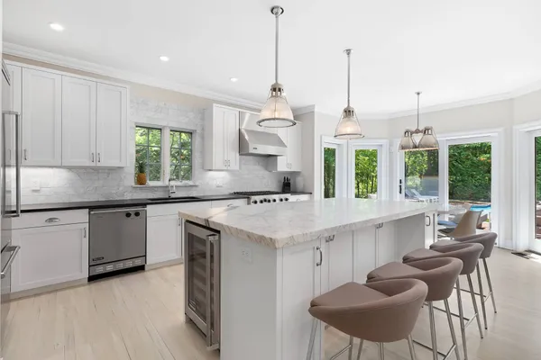 a kitchen with granite countertop white cabinets and window