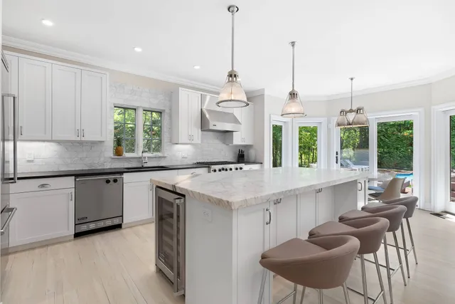 a kitchen with granite countertop white cabinets and window
