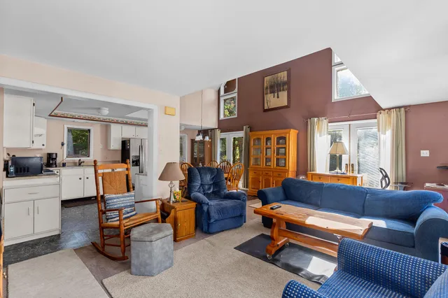 a living room with furniture kitchen view and a large window