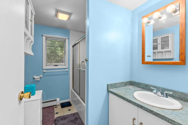 a bathroom with a granite countertop sink and a mirror