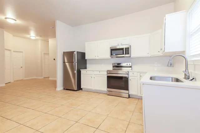 a kitchen with stainless steel appliances granite countertop a refrigerator sink and stove
