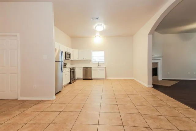 a view of a kitchen with a sink and an empty room