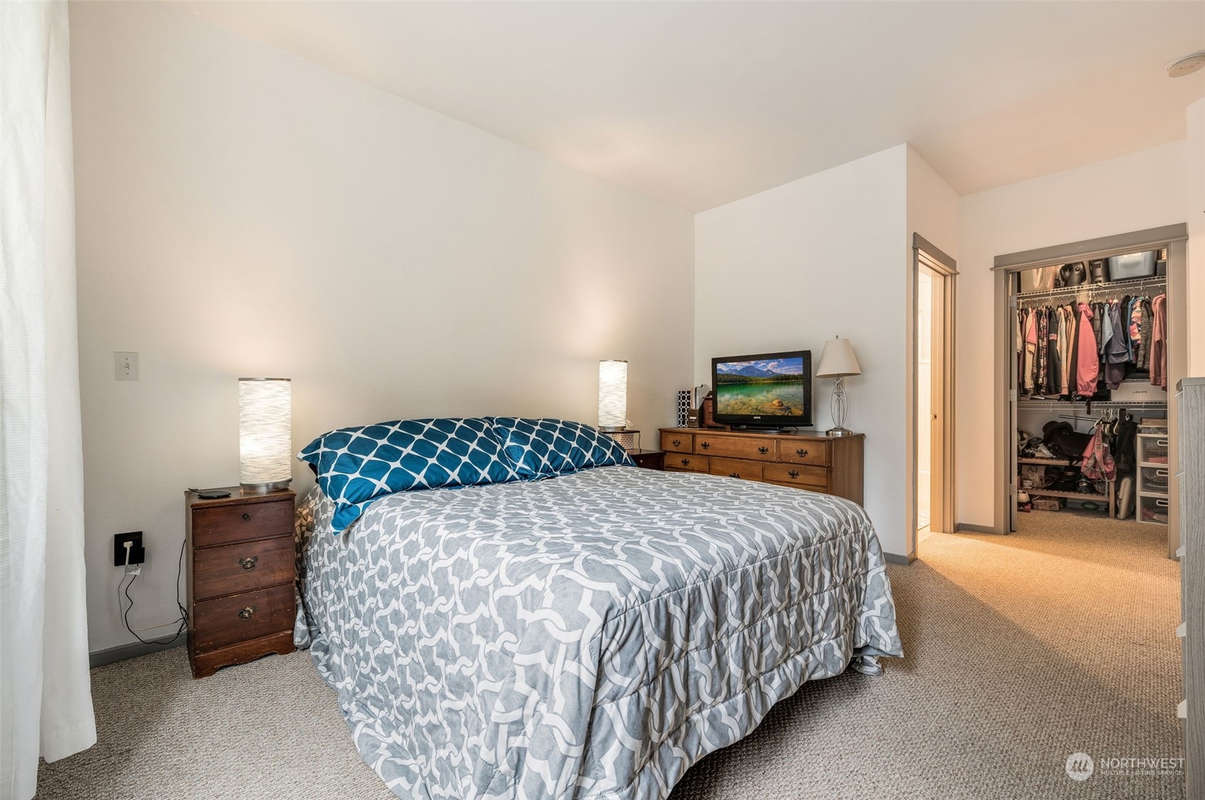 2009 196th Street Southeast, Unit F102 Bothell, WA 98012 - Photo 13 of 18 a bedroom with a large bed and a flat tv screen on dresser