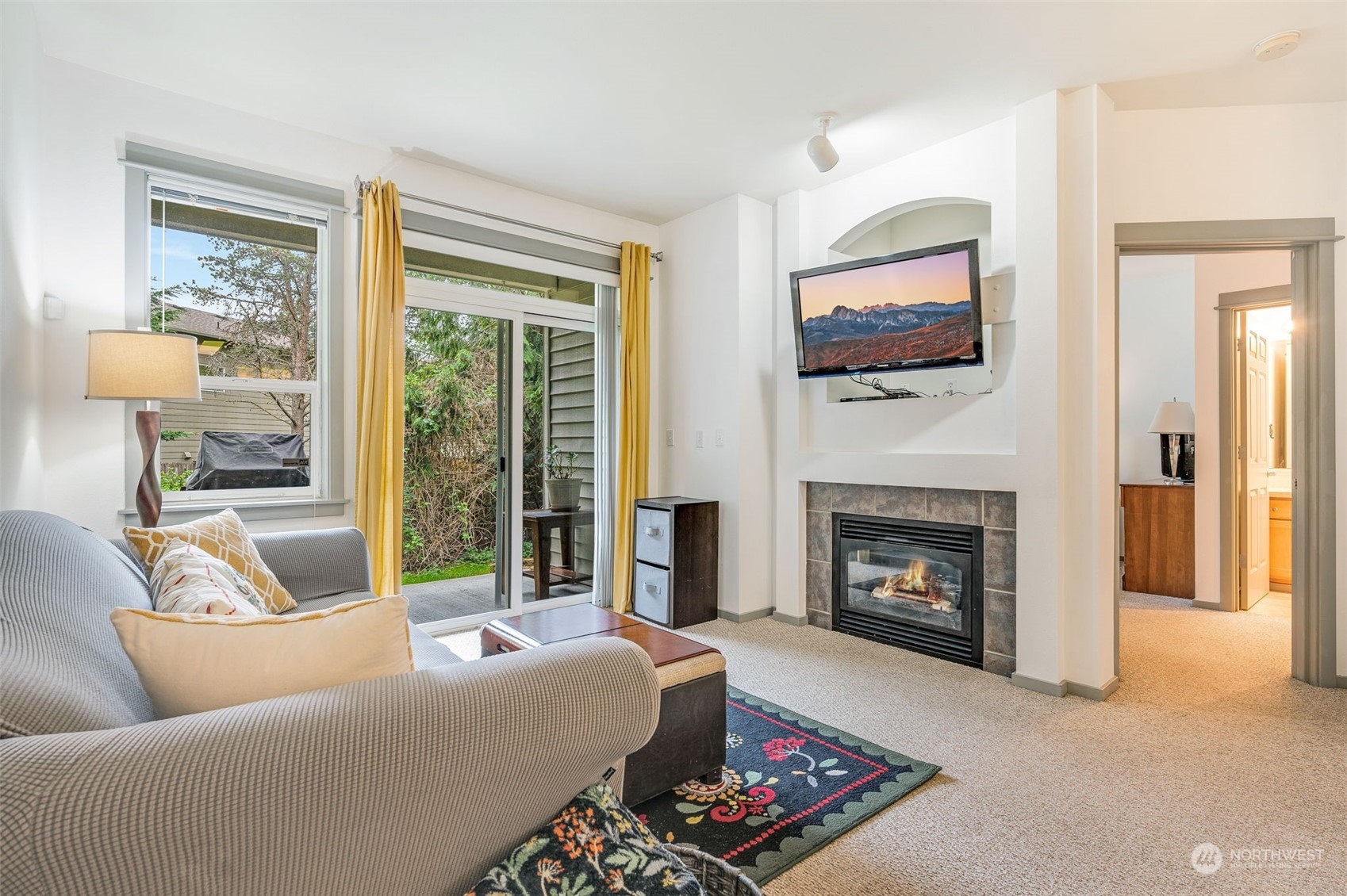 2009 196th Street Southeast, Unit F102 Bothell, WA 98012 - Photo 5 of 18 a living room with furniture a flat screen tv and a fireplace
