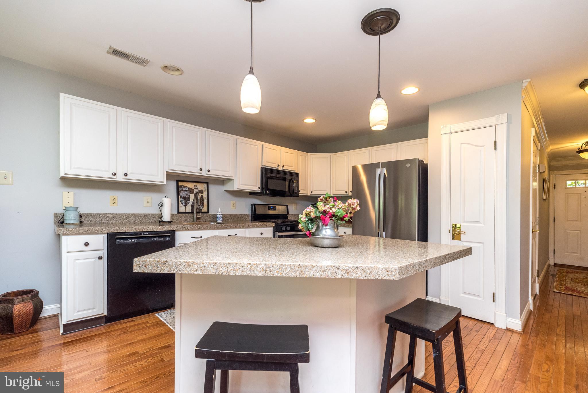 329 Manor Road Harleysville, PA 19438 - Photo 14 of 39 a kitchen with stainless steel appliances granite countertop a sink a stove a refrigerator cabinets and chairs