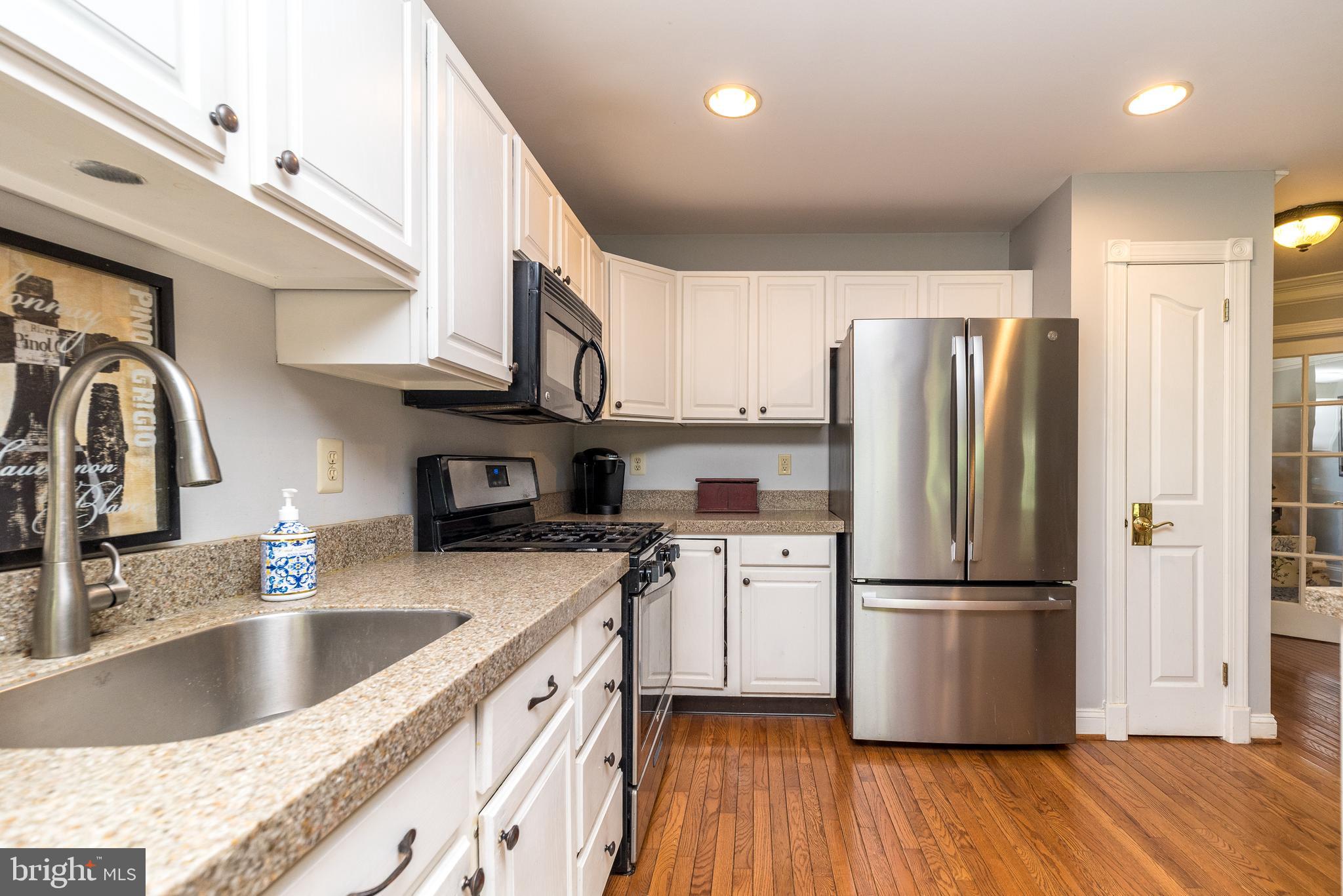 329 Manor Road Harleysville, PA 19438 - Photo 15 of 39 a kitchen with stainless steel appliances granite countertop a refrigerator a sink dishwasher a stove with wooden floors