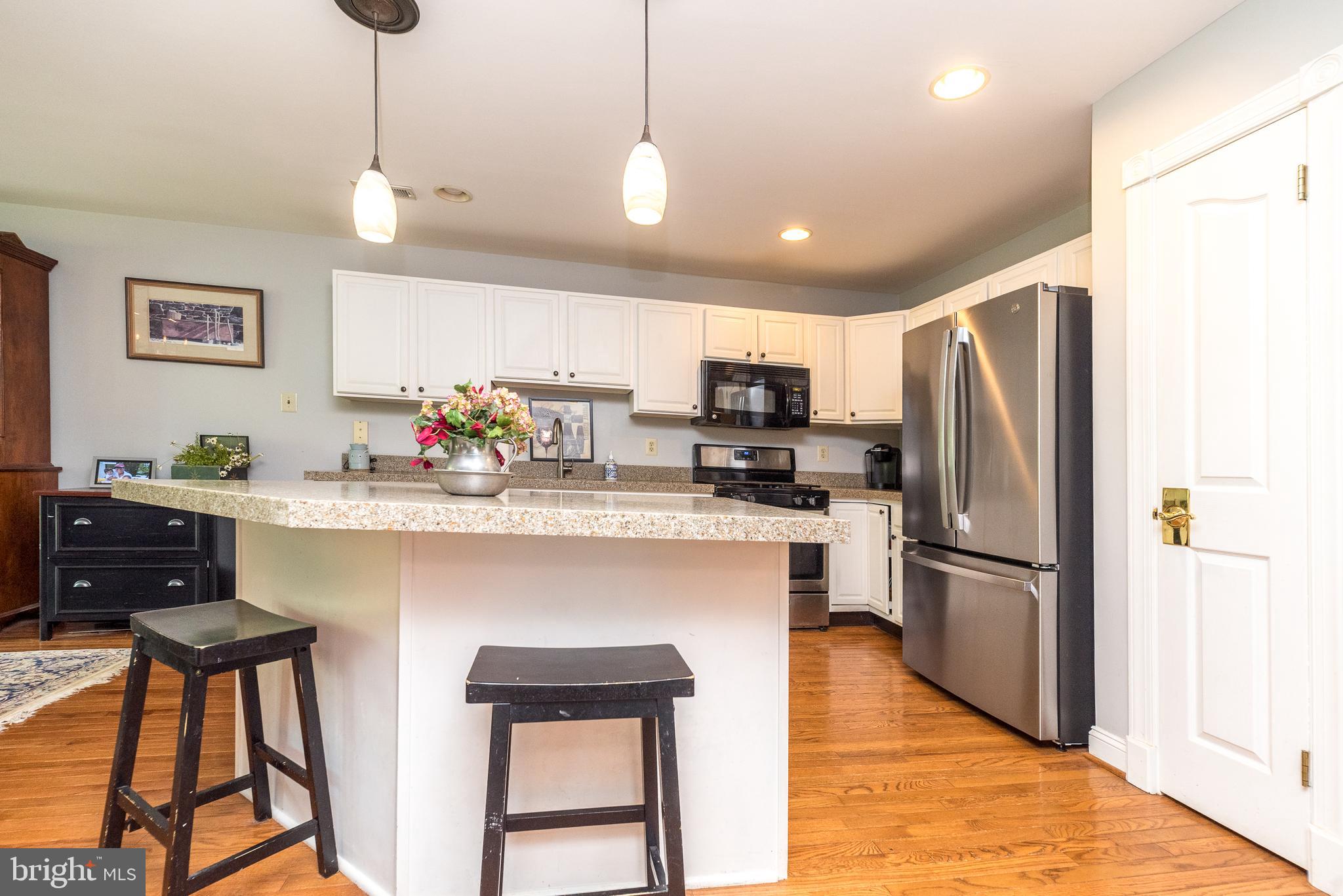 329 Manor Road Harleysville, PA 19438 - Photo 16 of 39 a kitchen with stainless steel appliances granite countertop a refrigerator a stove a sink dishwasher and a refrigerator with wooden floor
