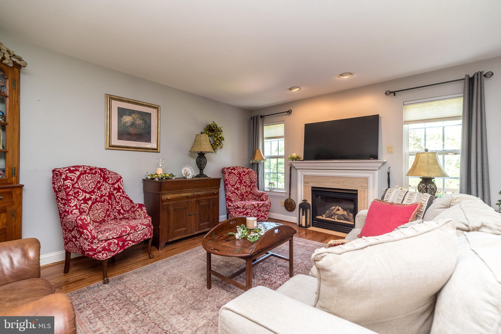 329 Manor Road Harleysville, PA 19438 - Photo 8 of 39 a living room with furniture a flat screen tv and a fireplace