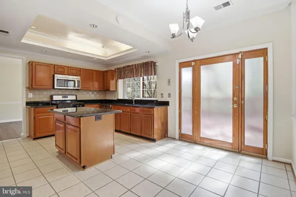 a kitchen with stainless steel appliances granite countertop a stove a sink dishwasher and a refrigerator