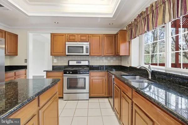 a kitchen with stainless steel appliances granite countertop a sink stove and cabinets