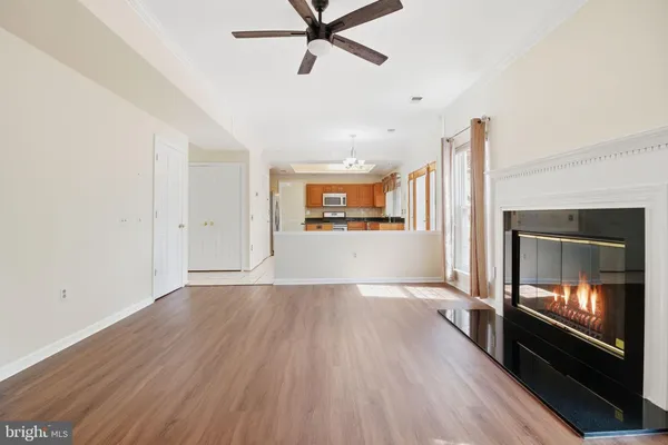 a view of a livingroom with wooden floor and a ceiling fan