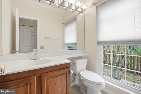 a bathroom with a sink vanity mirror and toilet