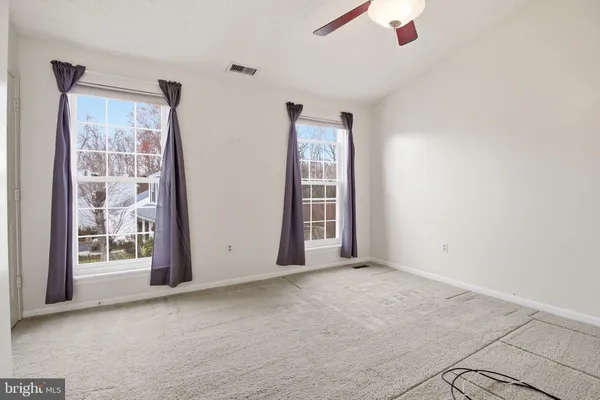 an empty room with windows and closet