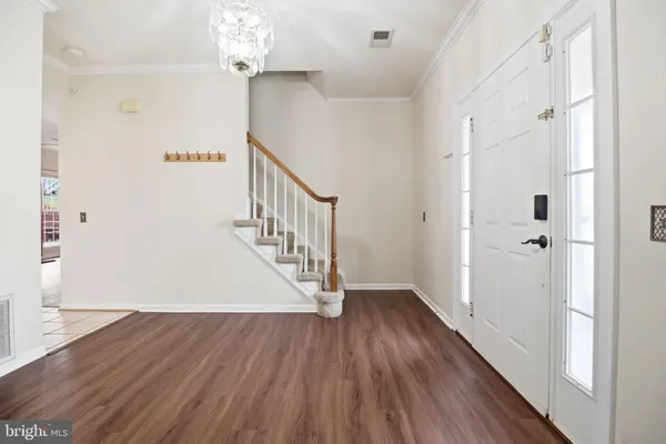 a view of a hallway with wooden floor and staircase