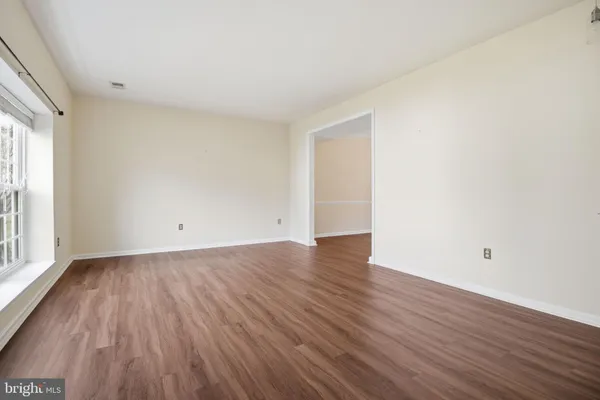 a view of a room with wooden floor and white walls