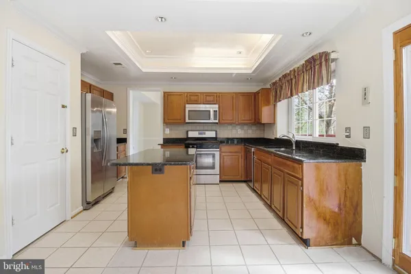 a kitchen with stainless steel appliances granite countertop a stove top oven a sink a counter top space and cabinets