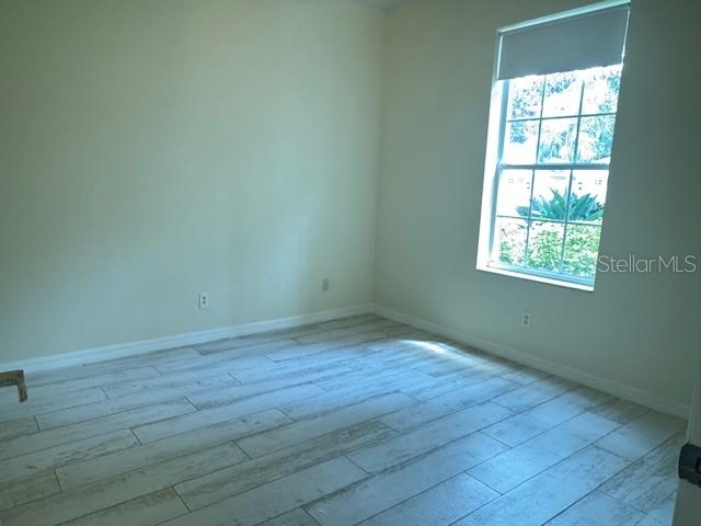 5511 Key W Place, Unit 5511 Bradenton, FL 34203 - Photo 11 of 38 an empty room with wooden floor and windows