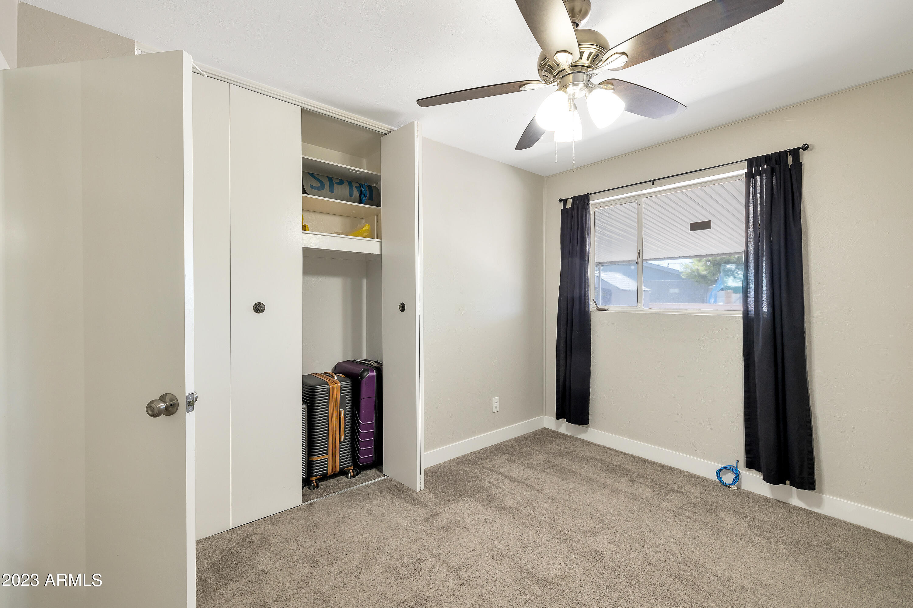 5473 West Osborn Road Phoenix, AZ 85031 - Photo 22 of 37 a view of a livingroom with a chandelier fan and closet area