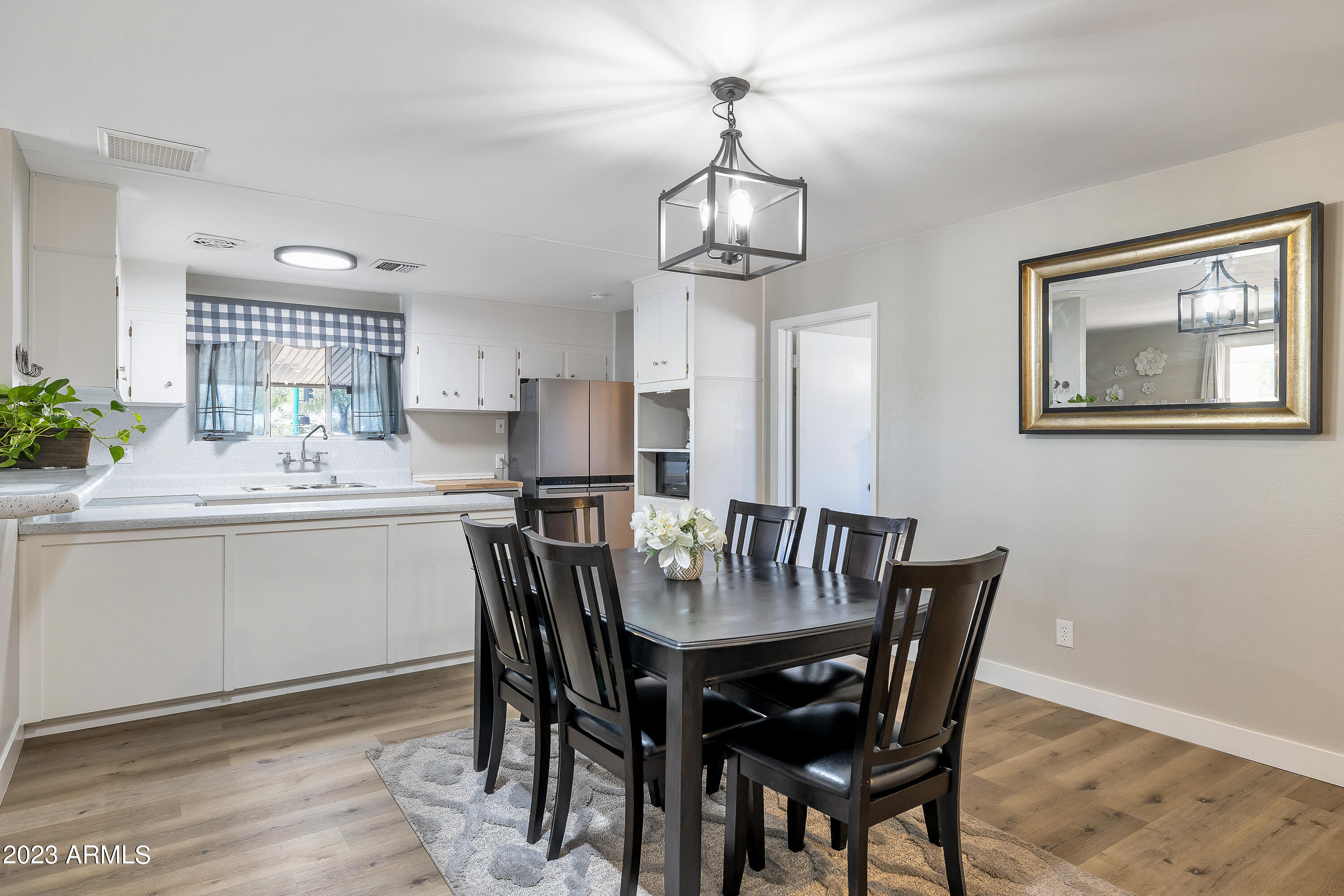 5473 West Osborn Road Phoenix, AZ 85031 - Photo 7 of 37 a view of a dining room with furniture a chandelier and wooden floor