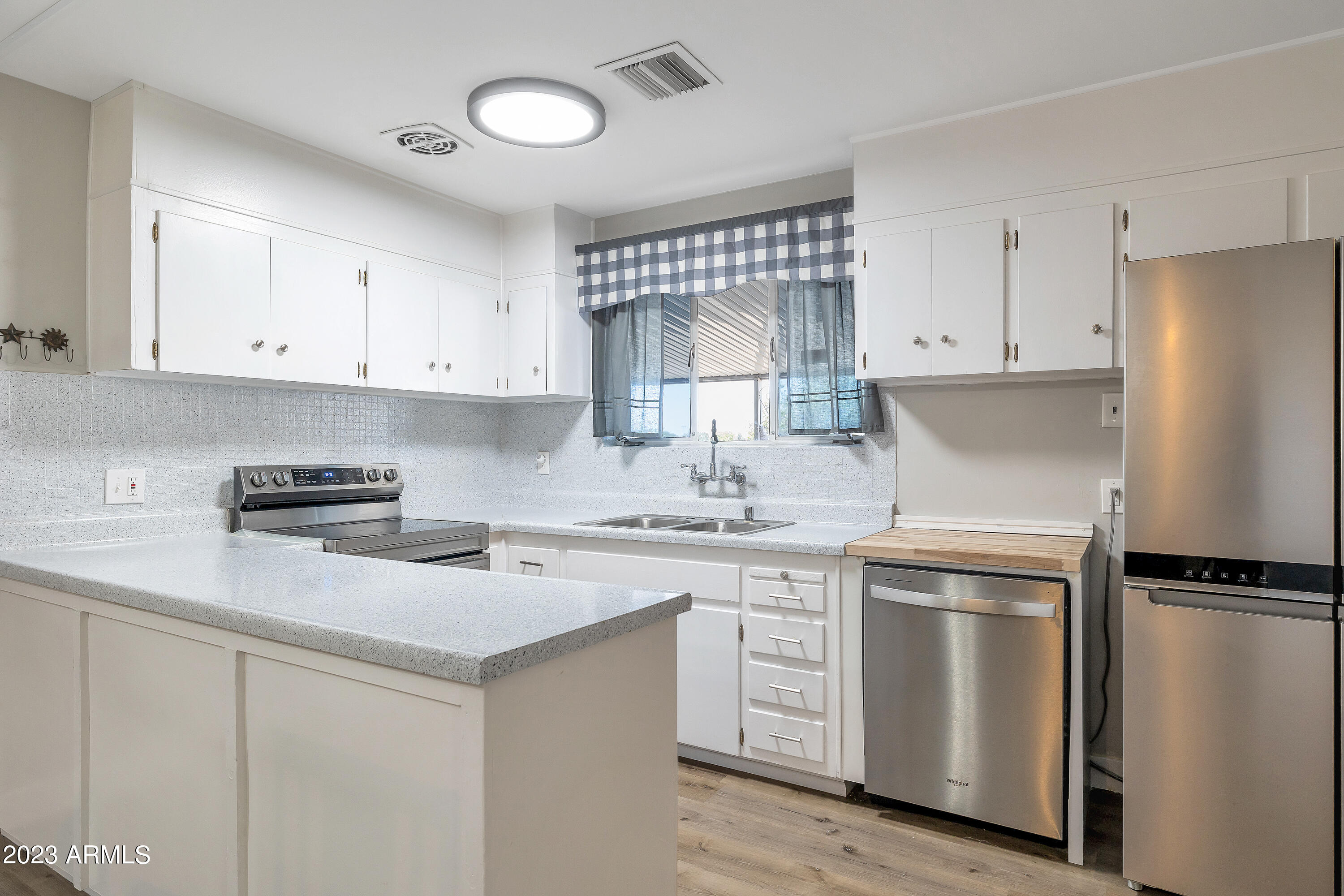 5473 West Osborn Road Phoenix, AZ 85031 - Photo 8 of 37 a kitchen with white cabinets and white appliances