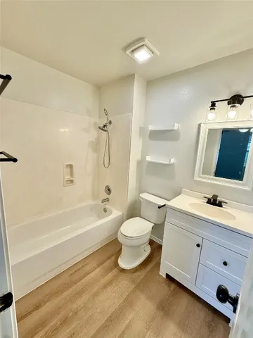 a bathroom with a double vanity sink toilet mirror and bathtub