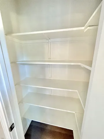 a view of walk in closet with empty racks
