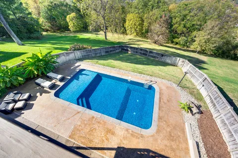 a view of a swimming pool with a yard and sitting area