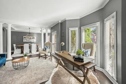 a dining room with furniture a chandelier and wooden floor