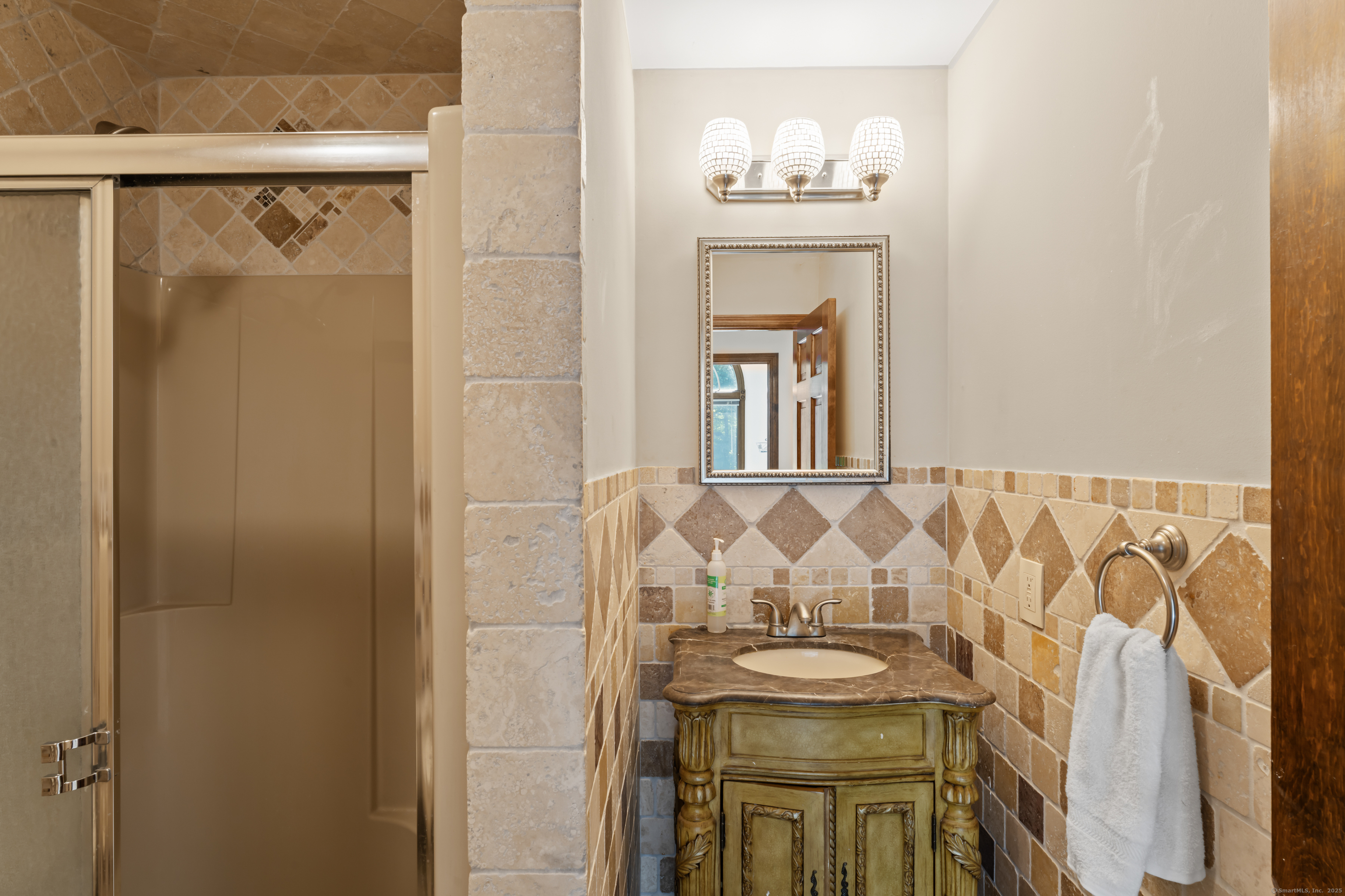501 Woodbine Road Stamford, CT 06903 - Photo 25 of 37 a bathroom with a sink and mirror with bathtub