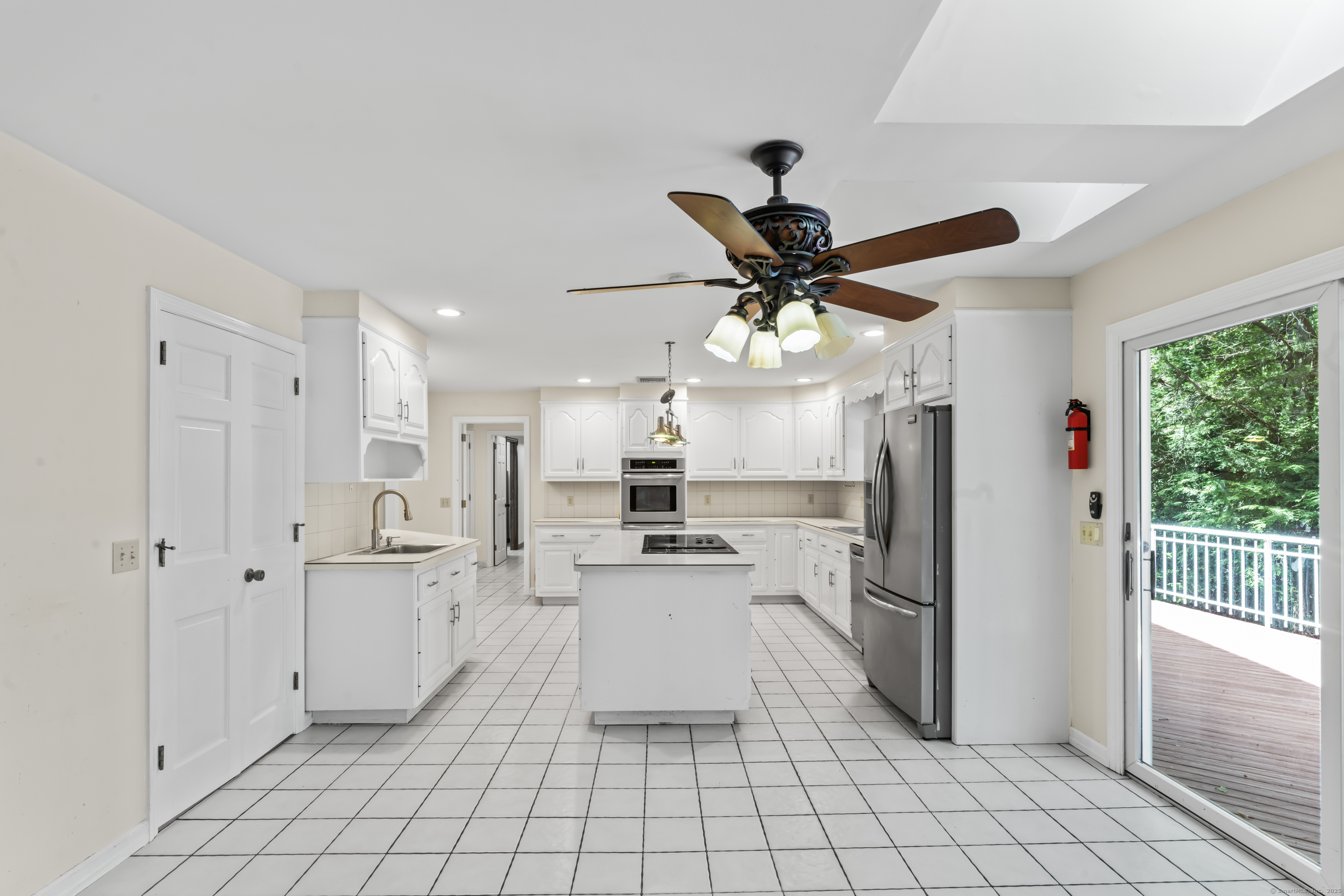 501 Woodbine Road Stamford, CT 06903 - Photo 7 of 37 a kitchen with granite countertop a refrigerator and white cabinets