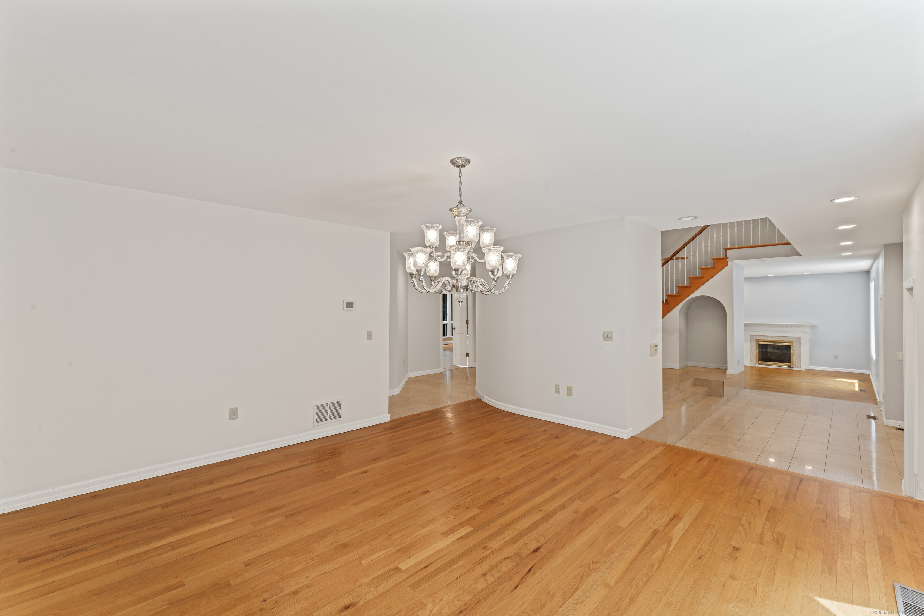 501 Woodbine Road Stamford, CT 06903 - Photo 8 of 37 a view of a big room with wooden floor and chandelier