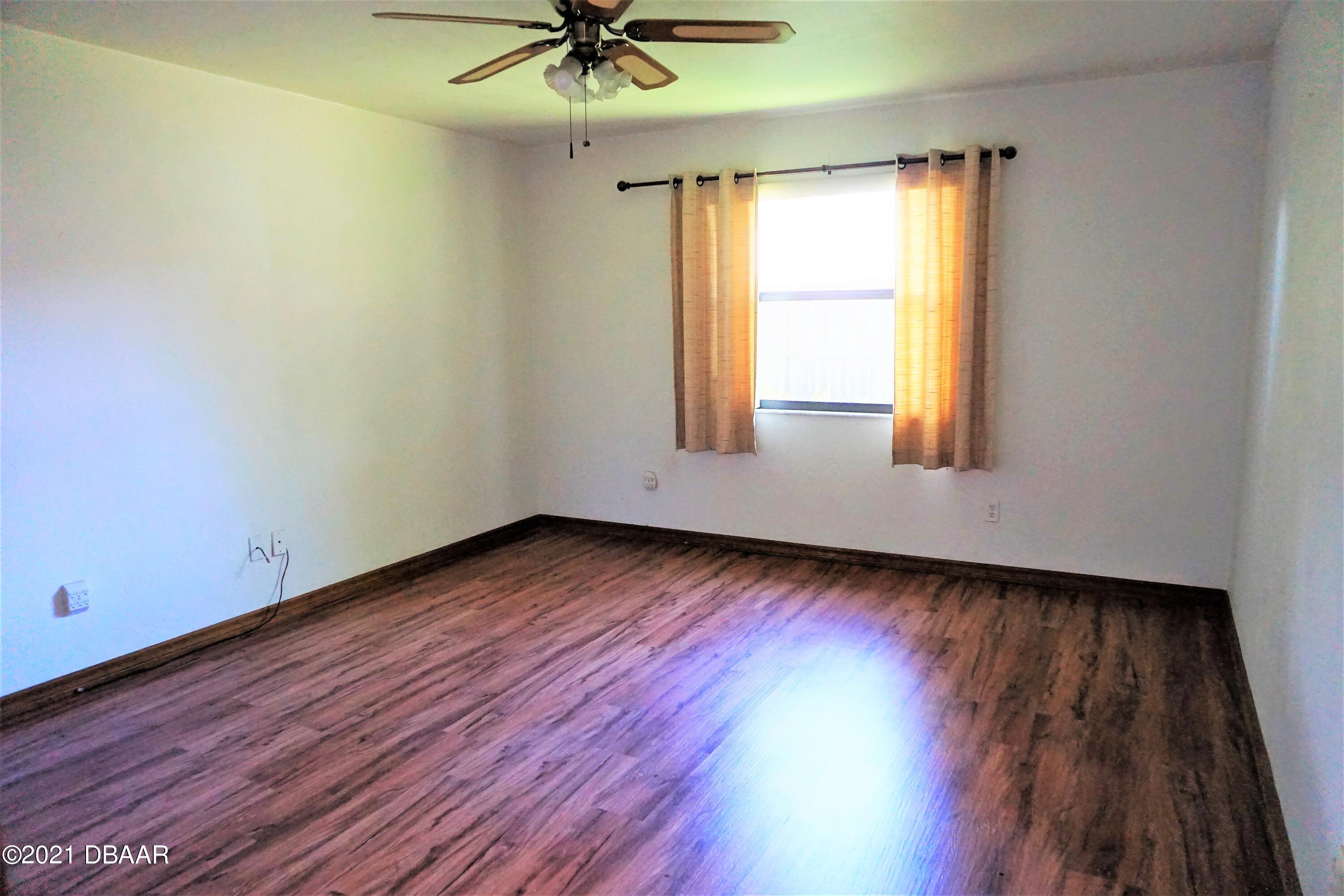 12 Charleston Square Ormond Beach, FL 32174 - Photo 11 of 26 an empty room with wooden floor and windows