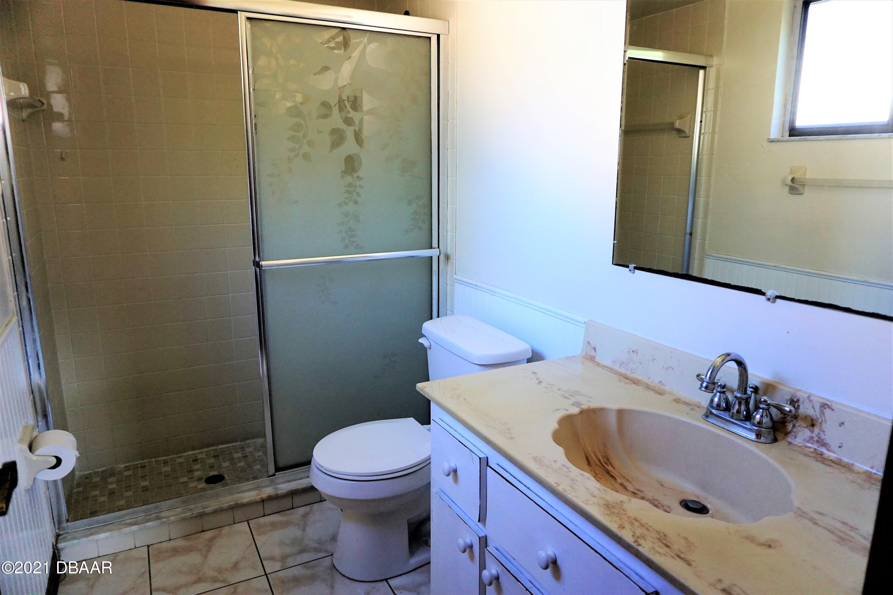 12 Charleston Square Ormond Beach, FL 32174 - Photo 13 of 26 a bathroom with a sink a toilet and shower
