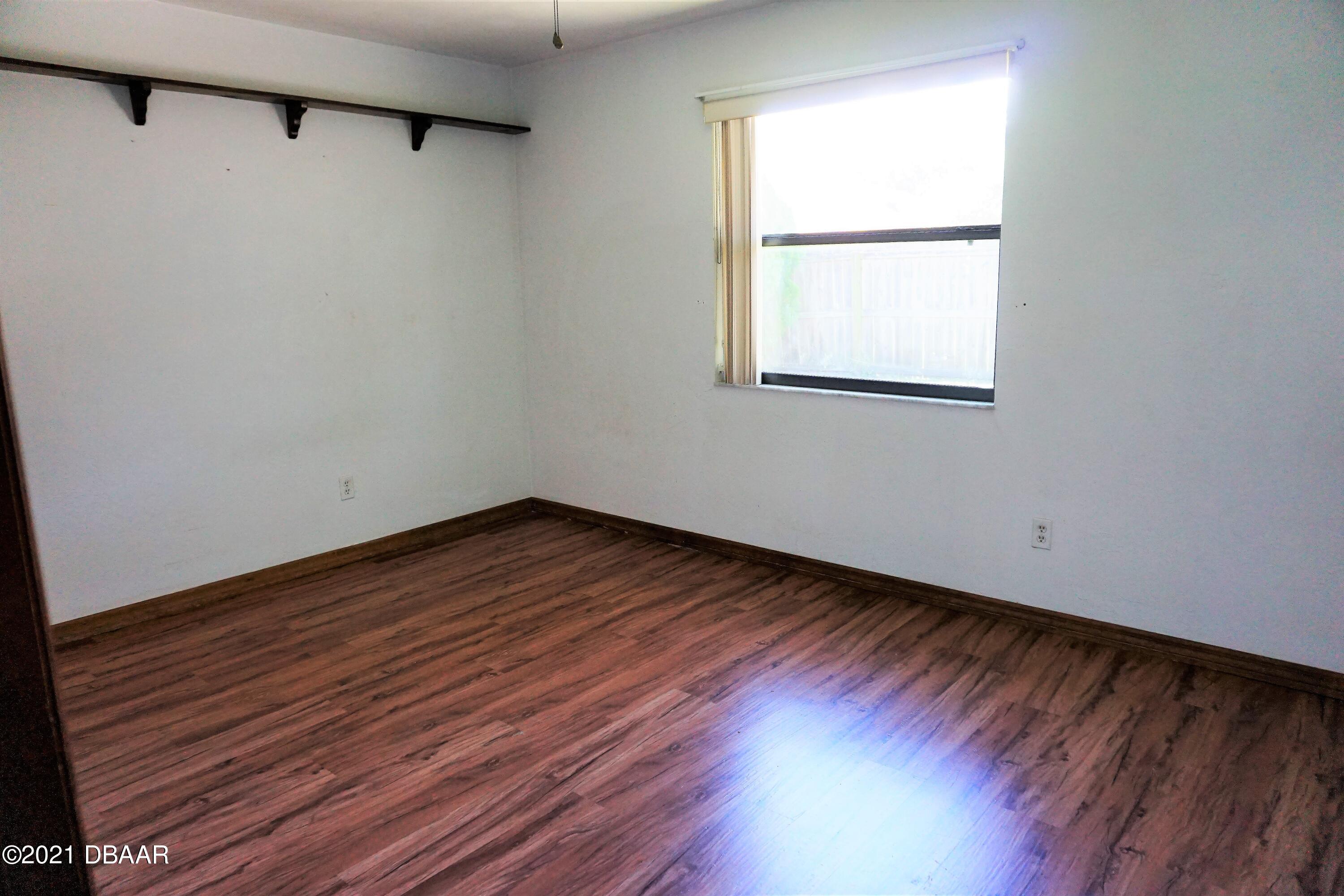 12 Charleston Square Ormond Beach, FL 32174 - Photo 16 of 26 a view of an empty room with wooden floor and a window