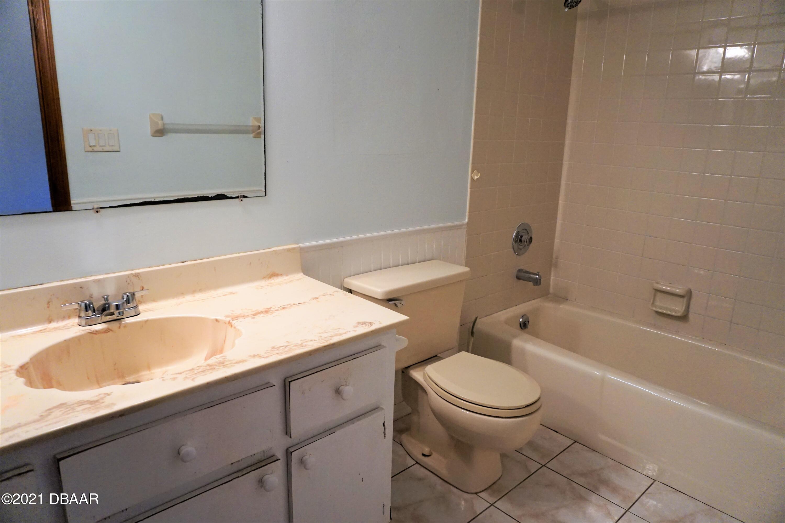 12 Charleston Square Ormond Beach, FL 32174 - Photo 19 of 26 a bathroom with a granite countertop toilet a sink and a bathtub