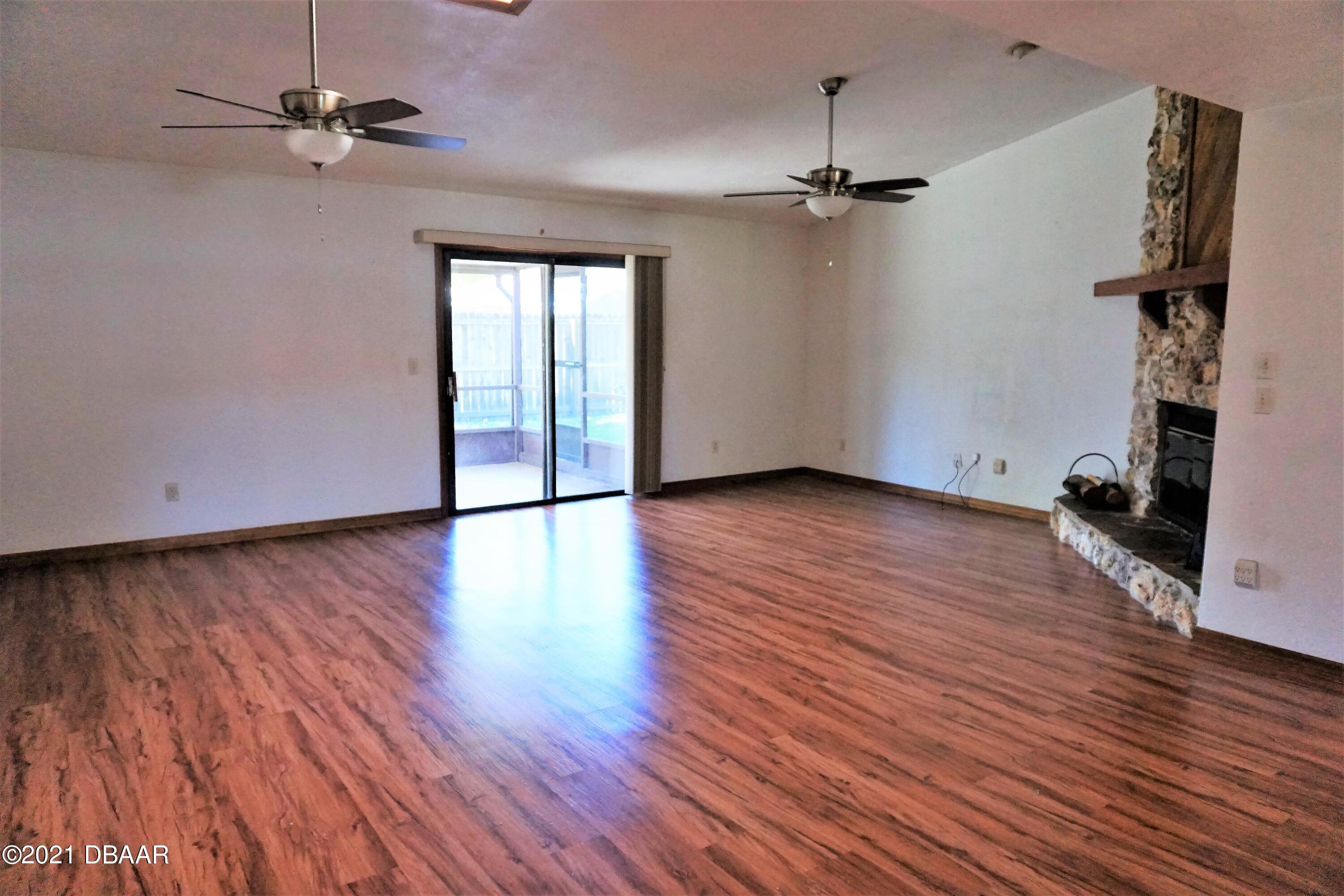 12 Charleston Square Ormond Beach, FL 32174 - Photo 3 of 26 wooden floor in an empty room with a window