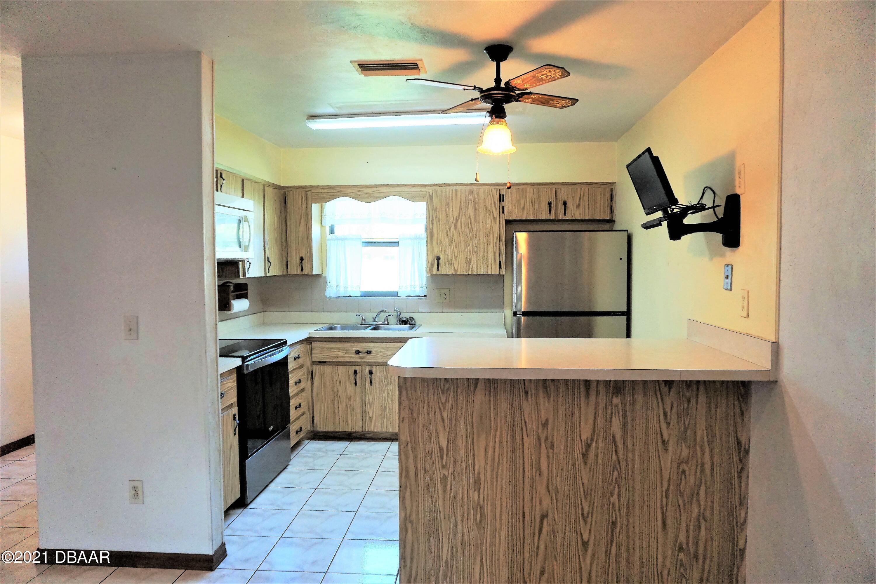 12 Charleston Square Ormond Beach, FL 32174 - Photo 6 of 26 a kitchen with a sink a refrigerator and a stove