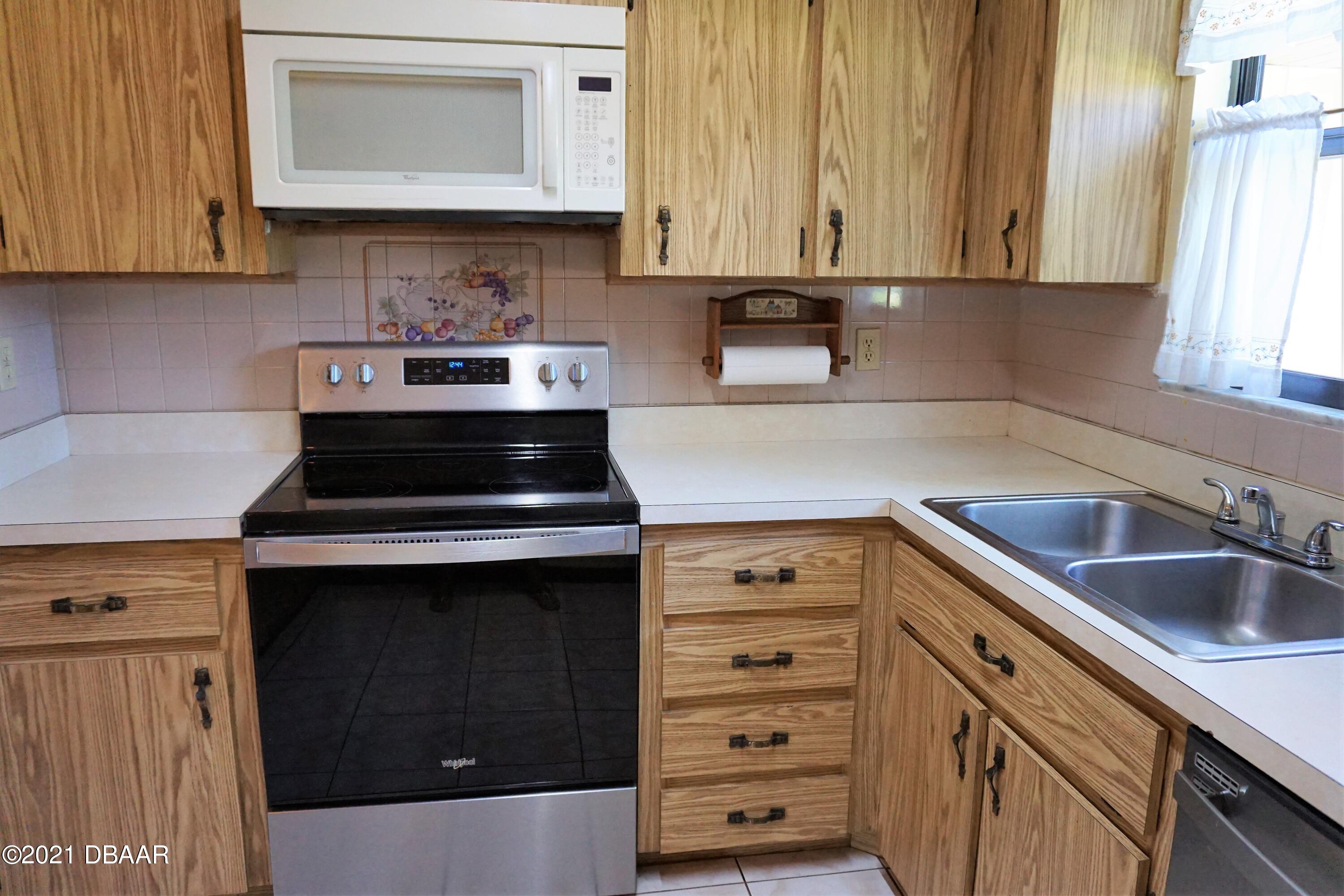 12 Charleston Square Ormond Beach, FL 32174 - Photo 7 of 26 a kitchen with granite countertop a stove and a sink