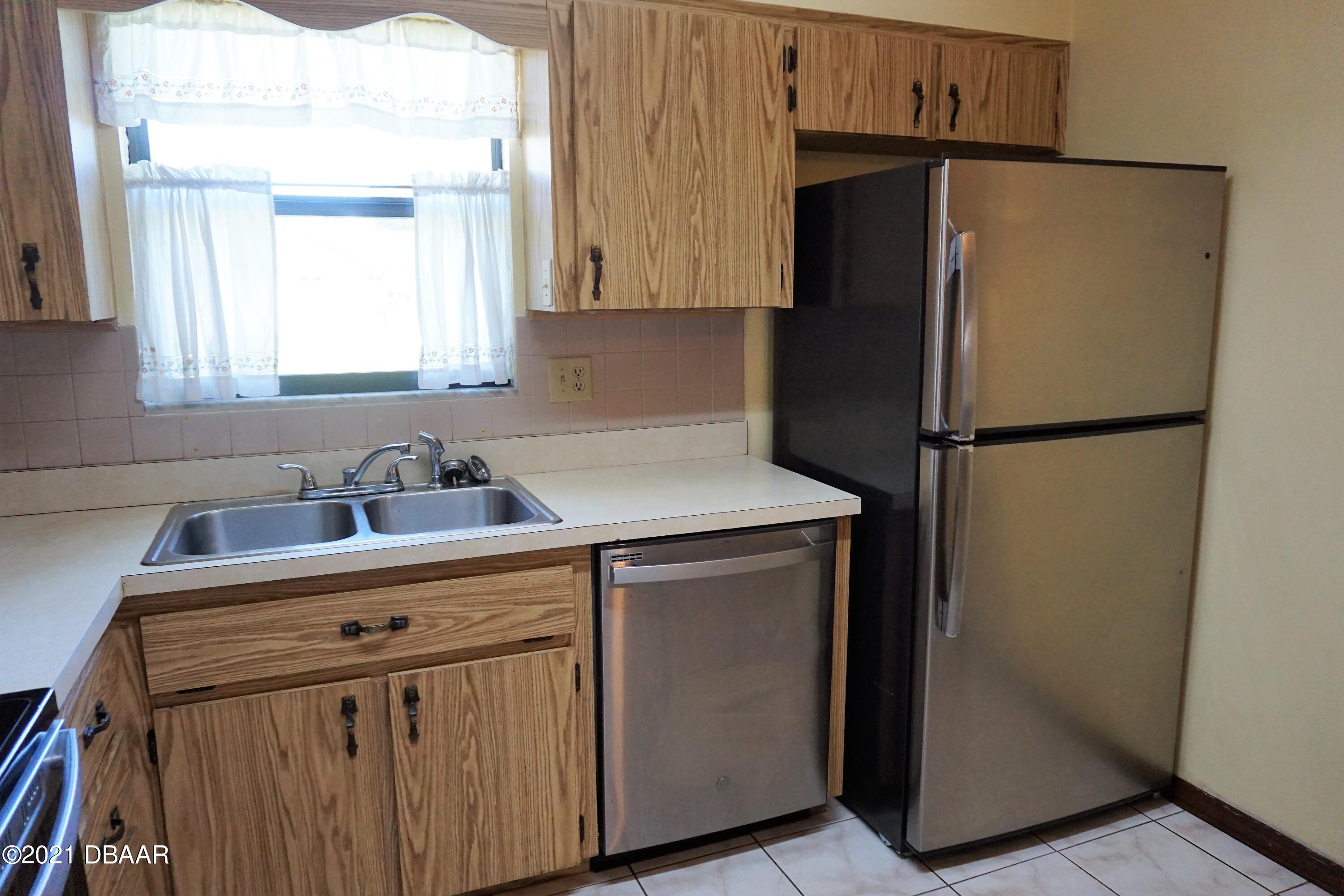 12 Charleston Square Ormond Beach, FL 32174 - Photo 8 of 26 a kitchen with a refrigerator sink and cabinets