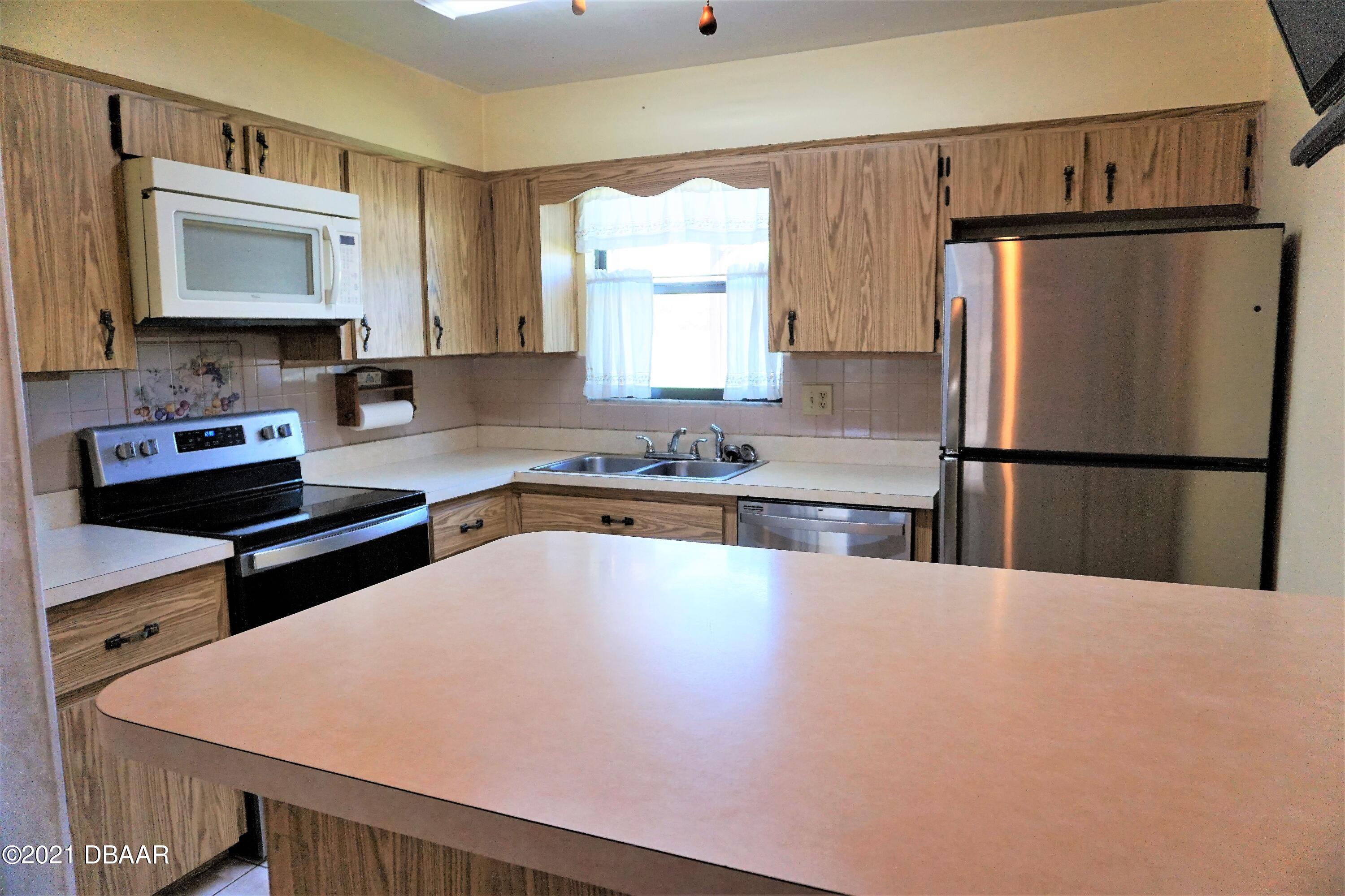 12 Charleston Square Ormond Beach, FL 32174 - Photo 9 of 26 a kitchen with stainless steel appliances a refrigerator sink and microwave