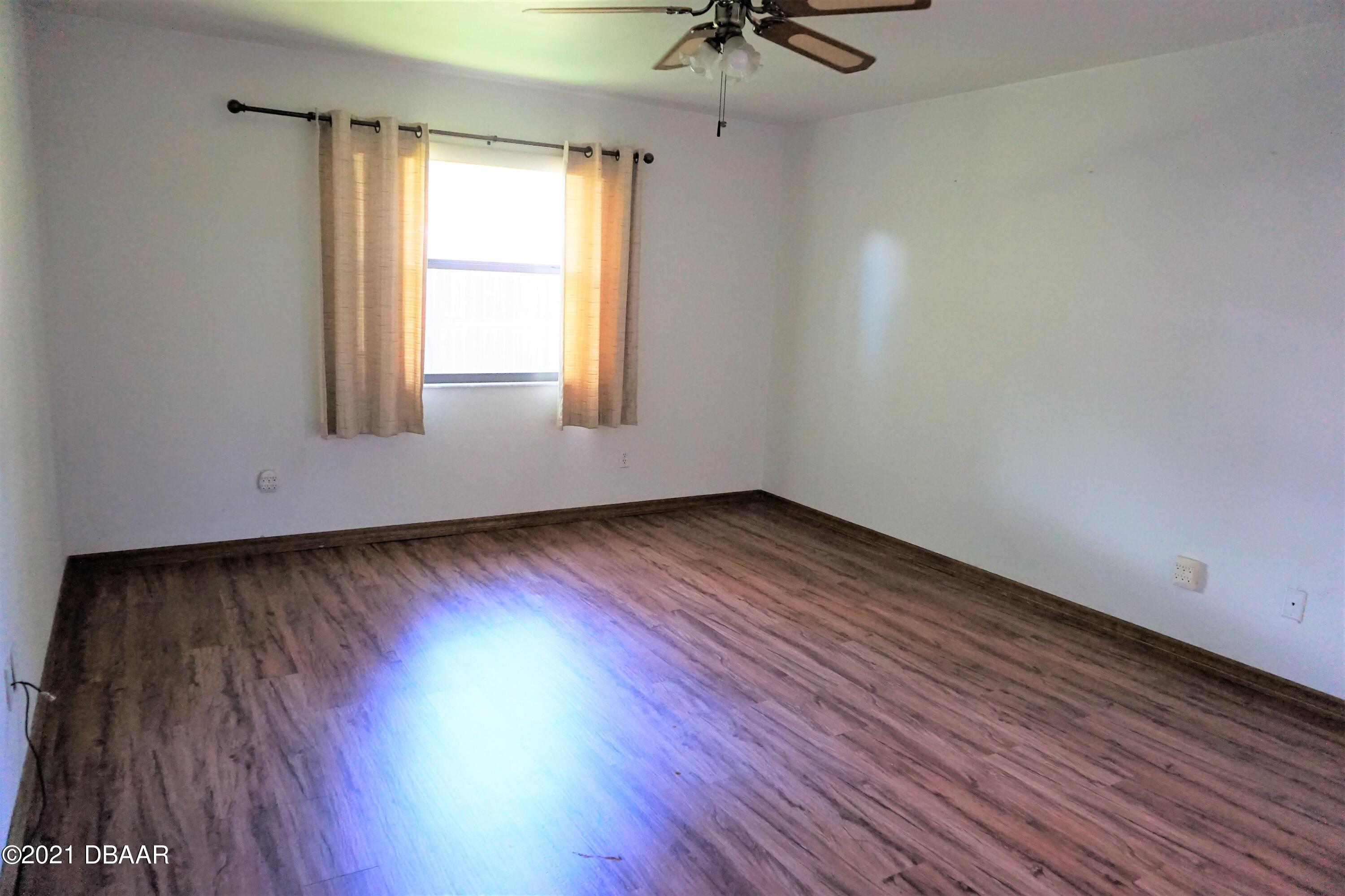 12 Charleston Square Ormond Beach, FL 32174 - Photo 10 of 26 wooden floor in an empty room with a window