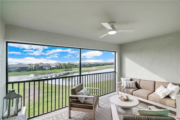 a living room with furniture and a floor to ceiling window